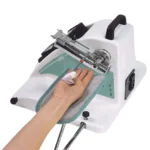 Therapy device for finger rehabilitation: a hand resting on a padded platform while a mechanical finger exerciser bands, spine and dial guide finger movement