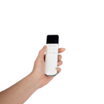 Hand holding a white remote control with a black top and a blue indicator light on the upper section.